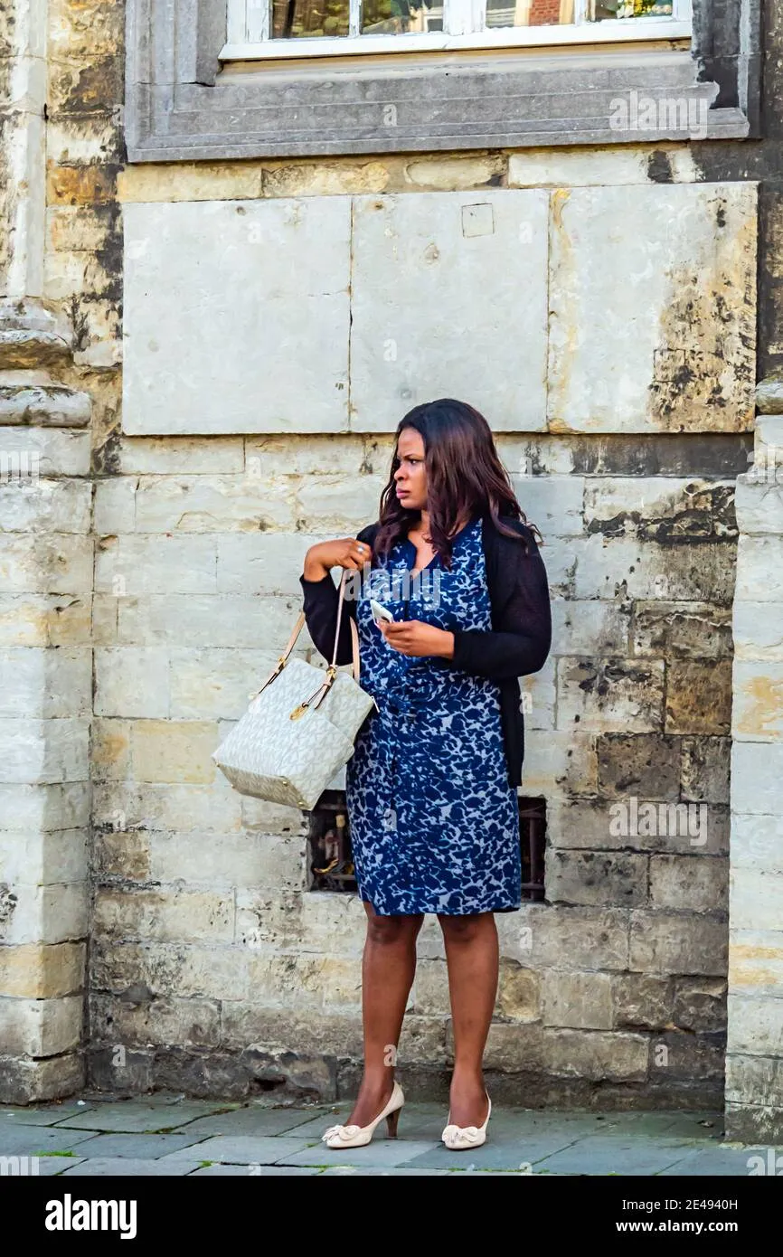 lovaina-belgium-aug-16-2015-afro-european-woman-with-michael-kors-bag-and-in-her-hand-with-a-communication-device-in-the-city-of-leuven-belgium-2e4940h Túi xách MK họa tiết chữ lồng là sự lựa chọn hoàn hảo cho phong cách năng động hàng ngày