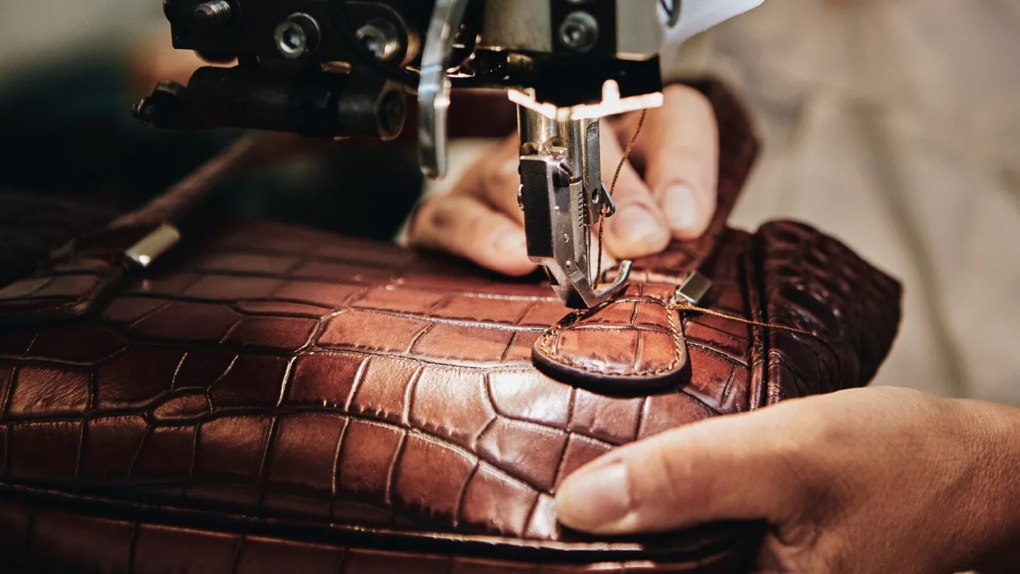 monogramme Sự tinh tế trong từng đường kim mũi chỉ và logo kim loại đặc trưng của túi xách nam Michael Kors
